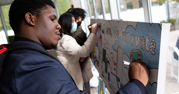 tradeshow attendee helping create a group mural